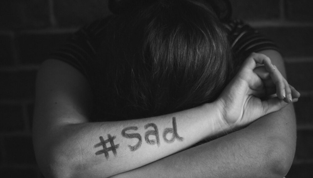 Girl with hashtag sad written on her arm pszichológia kereszténység